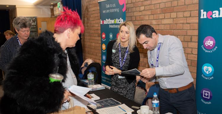 Woman speaking to member of public at community event